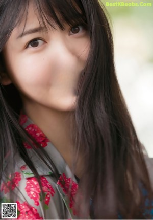 A woman with long brown hair wearing a white shirt.