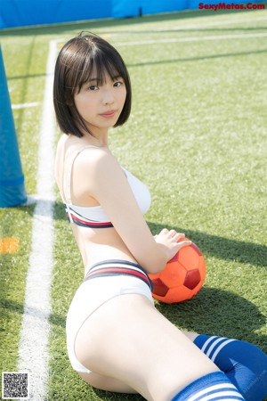A woman in a blue and white uniform on a soccer field.