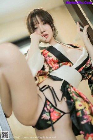 A woman in a black and red kimono is posing for the camera.
