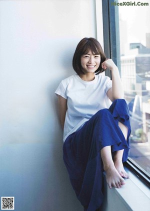 A woman in a plaid shirt is posing for a magazine.