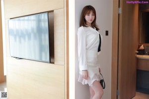 A woman in a white lingerie posing for a picture.