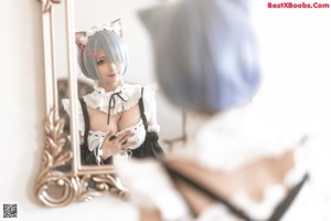 A woman in a maid outfit sitting on a chair.