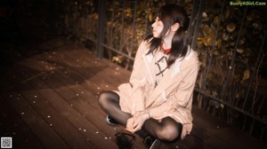 A woman in a pink jacket and black stockings posing for a picture.