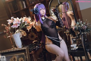 A woman with purple hair sitting on the floor.