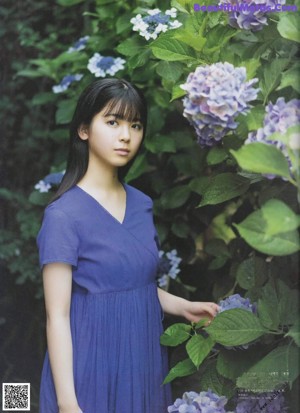 A woman in a blue dress is walking on a pier.