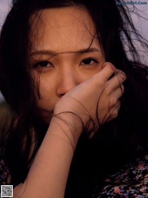 A woman holding a bunch of dry grass in her hands.