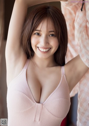 A woman in a pink bodysuit posing for a picture.