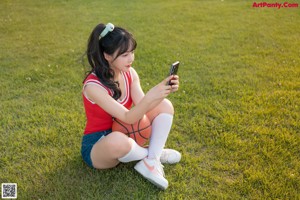 A woman sitting on a bench with a basketball.
