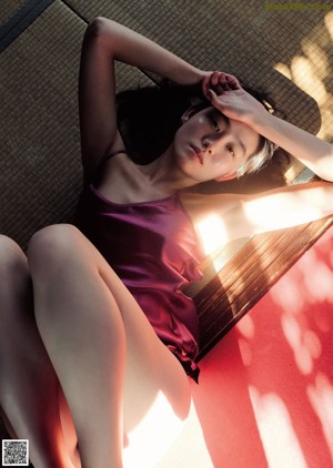 A woman in a white lingerie sitting on a stool.