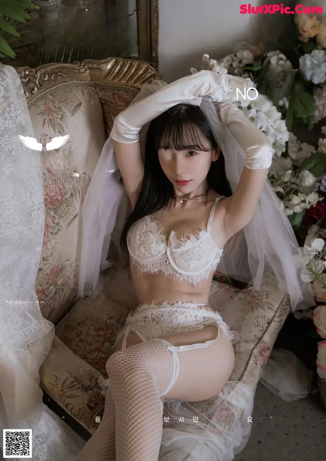 A woman in lingerie sitting on a chair in a room.