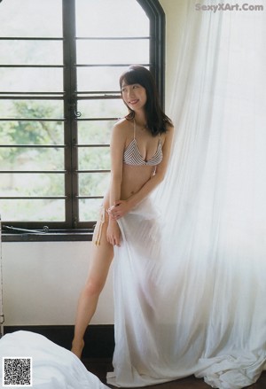 A woman sitting on top of a stool in a blue lingerie.