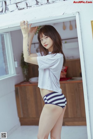 A woman in a white shirt and striped shorts posing for a picture.